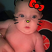 Delaney is registered to the contest to win money with this photo: baby, child, infant, face, hand, skin, whiskers, ears, red_bow, digital_filter, cute, portrait, expression, eyes, chubby, person, holding, indoors, playful, fun