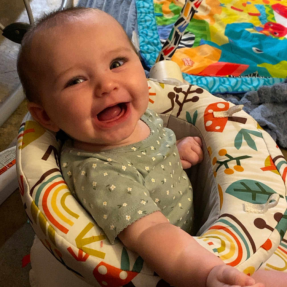 Laklyn is registered to the contest to win money with this photo: baby, babylaughing, bathroom, chair, cushion, face, furniture, happy, head, homedecor, indoors, laughing, person, photography, portrait, quilt, room, sitting, smile, toy