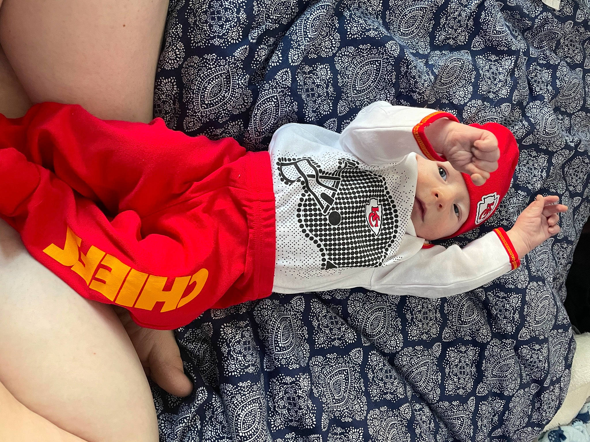 Hudson is registered to the contest to win money with this photo: baby, baby_products, baby_sleeping, baby_toddler_clothing, comfort, finger, hat, headgear, headwear, human_leg, knee, leg, linens, nail, pattern, person, sleeve, sock, sunglasses, textile