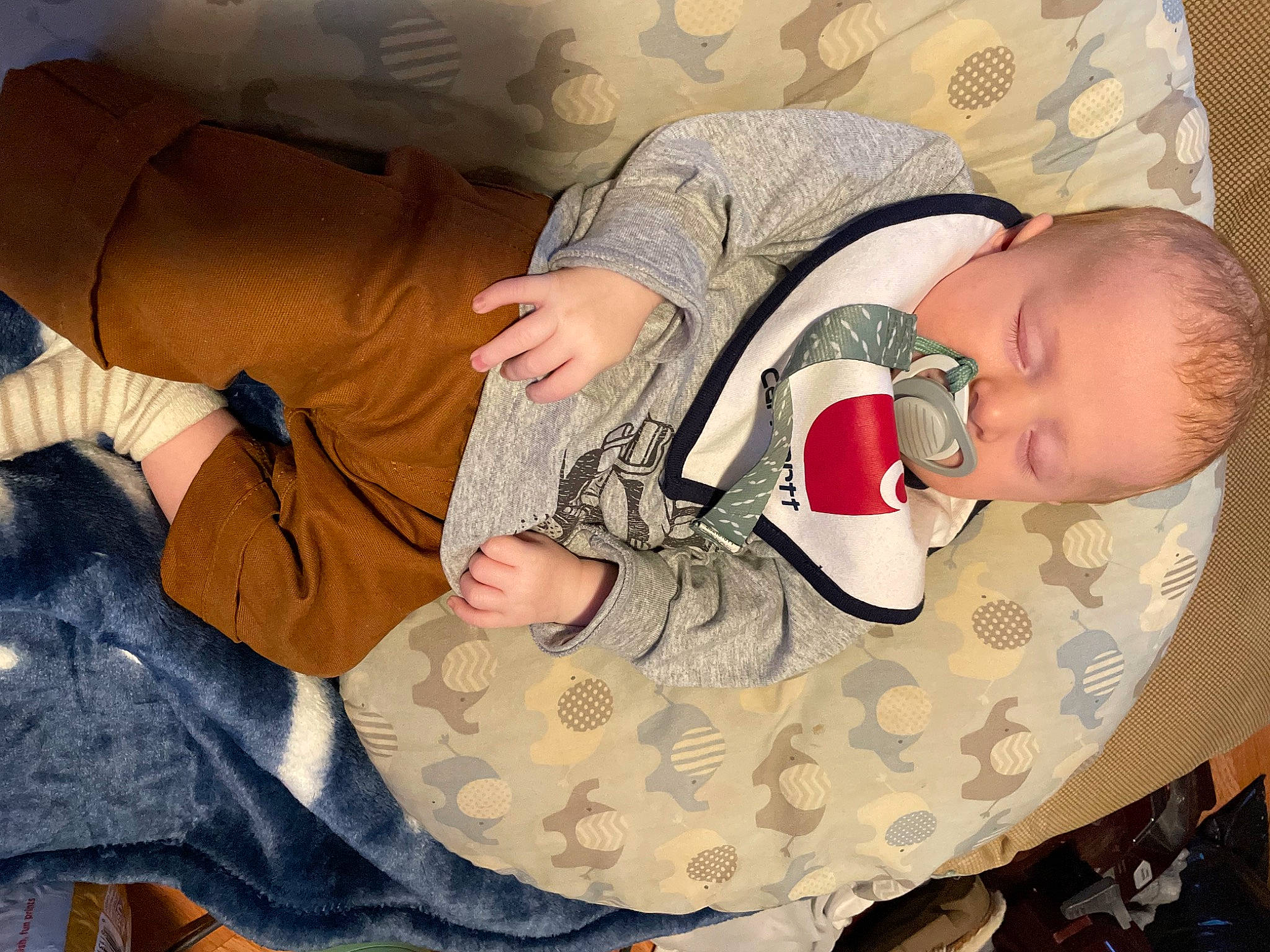 Hudson is registered to the contest to win money with this photo: baby, baby_products, baby_sleeping, baby_toddler_clothing, camouflage, child, comfort, finger, human_body, human_leg, infant_bed, joint, linens, military_camouflage, nap, pattern, person, sitting, textile, thigh