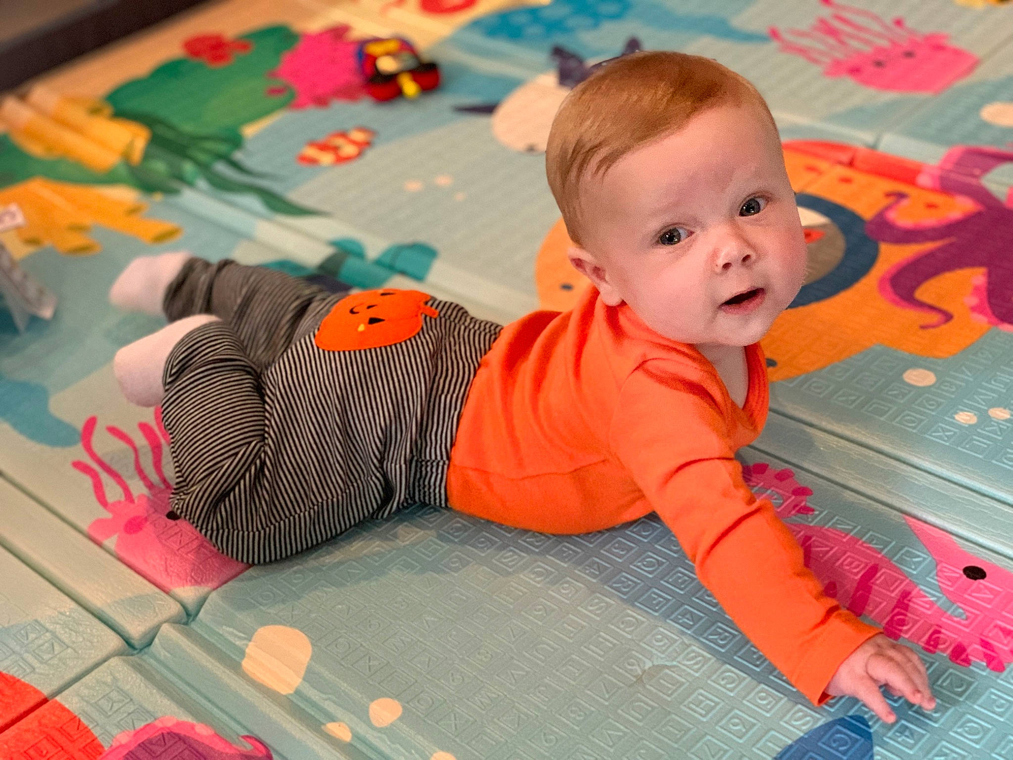 Adrian joined the competition — help win amazing prizes! baby, baby_toddler_clothing, baby_toys, child, comfort, floor, flooring, fun, happy, leisure, orange, pattern, person, play, playmat, room, sitting, sleeve, toddler, wood