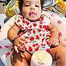 Walthour joined the competition — help win amazing prizes! baby, baby_seat, bottle, child, curious, curly_hair, cute, dress, footwear, fruit_pattern, hand, indoors, infant, pink, portrait, relaxed, sitting, skin, soft_lighting, white