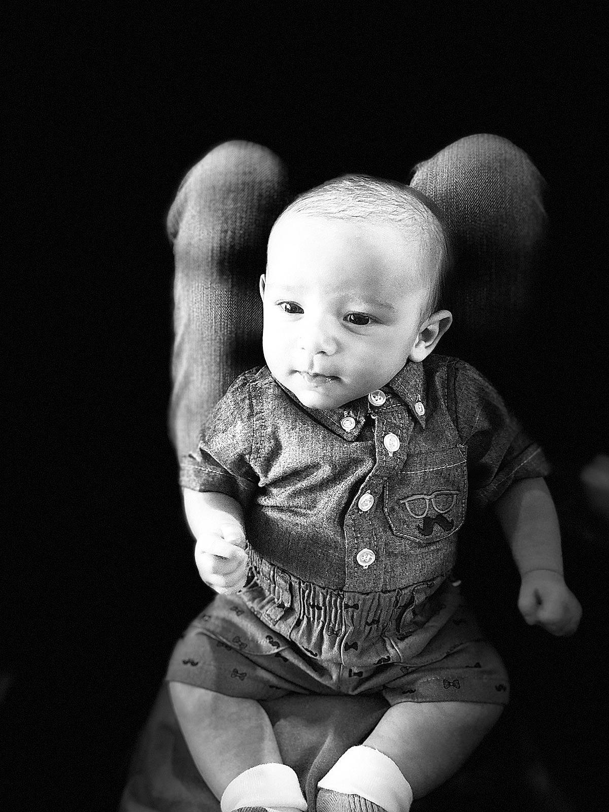 Hunter is registered to the contest to win money with this photo: baby, baby_toddler_clothing, black, black_and_white, cheek, darkness, eye, flash_photography, grey, happy, human_body, iris, lip, monochrome, monochrome_photography, person, sitting, sleeve, style, toddler