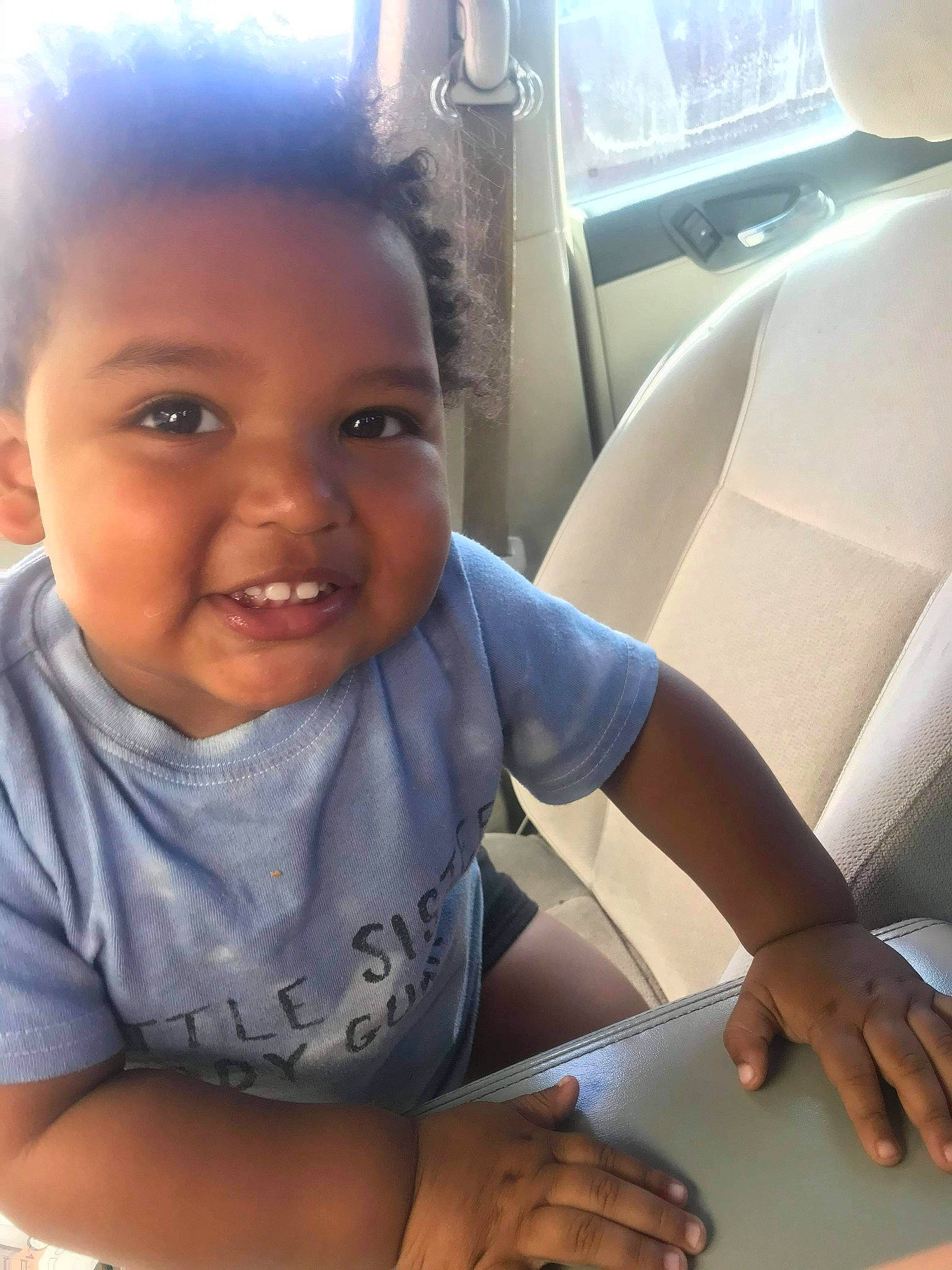 Sevyn is registered to the contest to win money with this photo: baby, car, car_seat_cover, cool, electronic_device, finger, fun, happy, head_restraint, joy, mouth, nose, person, skin, smile, snapshot, t_shirt, technology, thumb, toddler