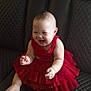 Melody Reign is registered to the contest to win money with this photo: baby, child, infant, red_dress, laughing, smiling, leather_couch, furniture, happy, cute, indoors, portrait, sitting, toddler, funny_face, plush, young, small, adorable, joy