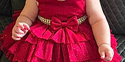 Melody Reign is registered to the contest to win money with this photo: baby, child, red_dress, smiling, happy, sitting, black_leather, chair, cute, ruffles, bow, infant, portrait, indoor, skin, person, fashion, young_child, expression, front_view