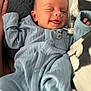 baby, infant, smiling, winking, tongue_out, blue_onesie, pacifier, blanket, cozy, sleepwear, cute, child, newborn, hand, face, portrait, lying_down, soft_texture, indoors, relaxed