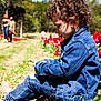 Ellie is registered to the contest to win money with this photo: child, toddler, denim_jacket, denim_jeans, curly_hair, outdoor, nature, tulips, flowers, grass, sunlight, playing, sitting, person, garden, spring, daylight, casual_clothing, people, trees