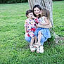 woman, child, children, tree, grass, outdoor, kiss, smile, nature, family, happy, casual_clothing, footwear, greenery, daylight, affection, crouching, young_girl, mother, garden