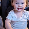 baby, candid, chair, child, close_up, cozy, eyes, face, happy, home, indoors, light_skin, portrait, red_hair, short_sleeves, sitting, smiling, teeth, toddler, white_shirt