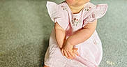 Maisie joined the competition — help win amazing prizes! baby, carpet, child, couch, cute, eyes, floor, foot, furniture, hair, hands, head, indoor, person, pink_dress, portrait, serious_expression, sitting, skin, young_child