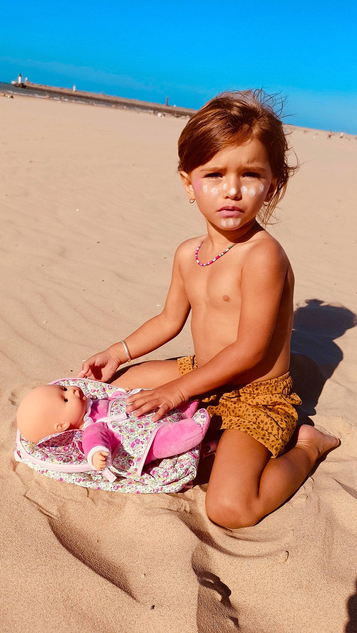 Livie participe au concours pour gagner de l'argent avec cette photo : barefoot, beach, beauty, blue, child, foot, fun, happy, human_body, human_leg, leg, leisure, people_in_nature, people_on_beach, person, sand, sitting, skin, sorrow, thigh
