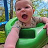 baby, child, swing, playground, outdoor, smiling, happy, green, tree, sky, nature, arm, face, clothing, infant, daylight, fun, baby_toddler, reaching, joyful