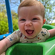 Zoey is registered to the contest to win money with this photo: baby, smiling, swing, green, outdoor, child, happy, playground, infant, joyful, face, nature, daylight, blue, tree, clothing, person, seat, cute, fun