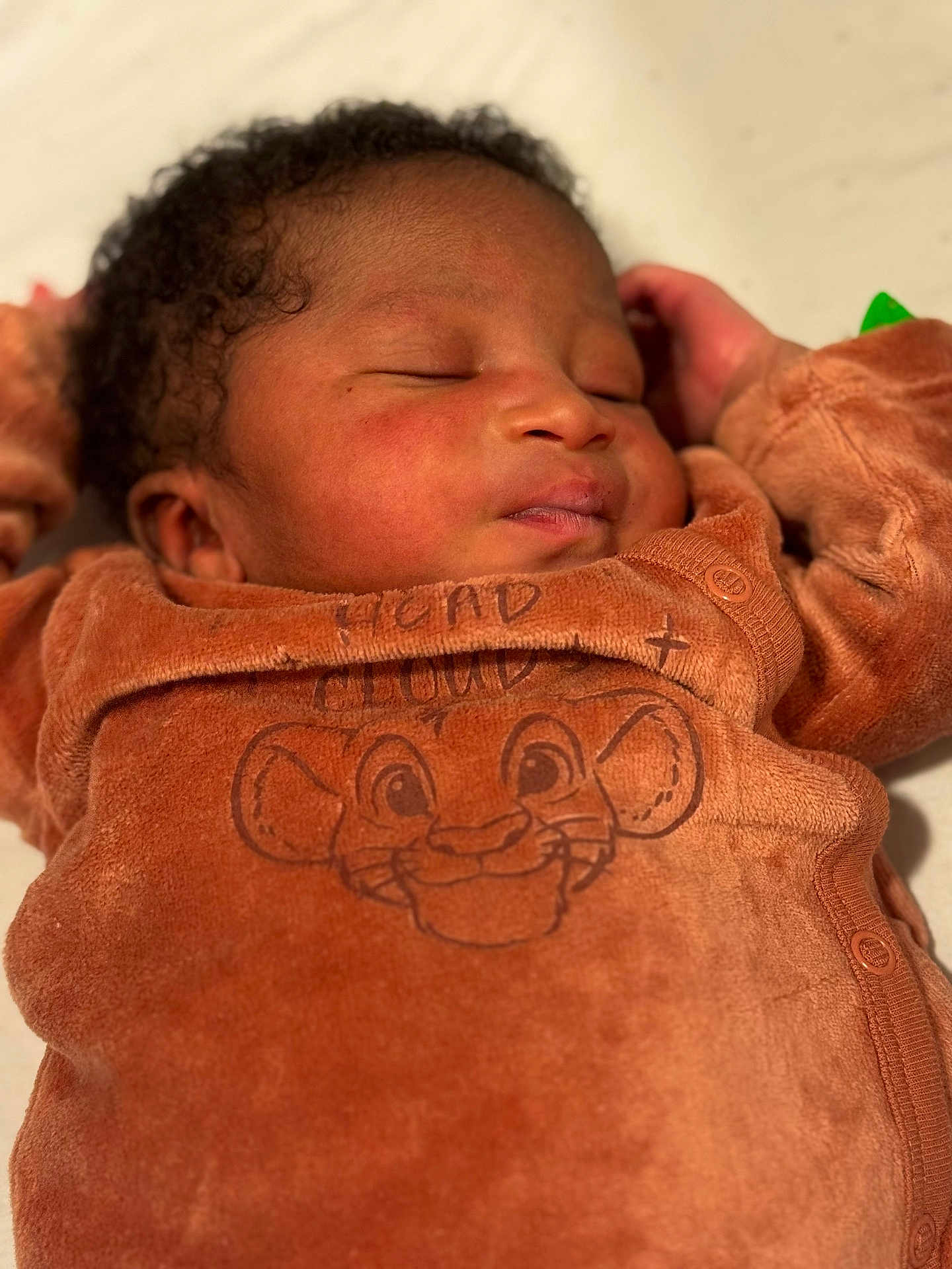 Ismaïl participe au concours pour gagner de l'argent avec cette photo : baby, sleeping, infant, child, cozy, brown_outfit, cartoon, lion_face, soft_lighting, closeup, peaceful, cute, person, portrait, newborn, clothing, hand, face, curly_hair, indoors