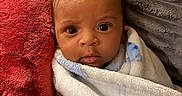 Ocean is registered to the contest to win money with this photo: baby, blanket, child, cozy, cushion, cute, expression, eyes, face, home, indoors, infant, person, pillow, portrait, snug, soft_texture, warm, wrapped, young