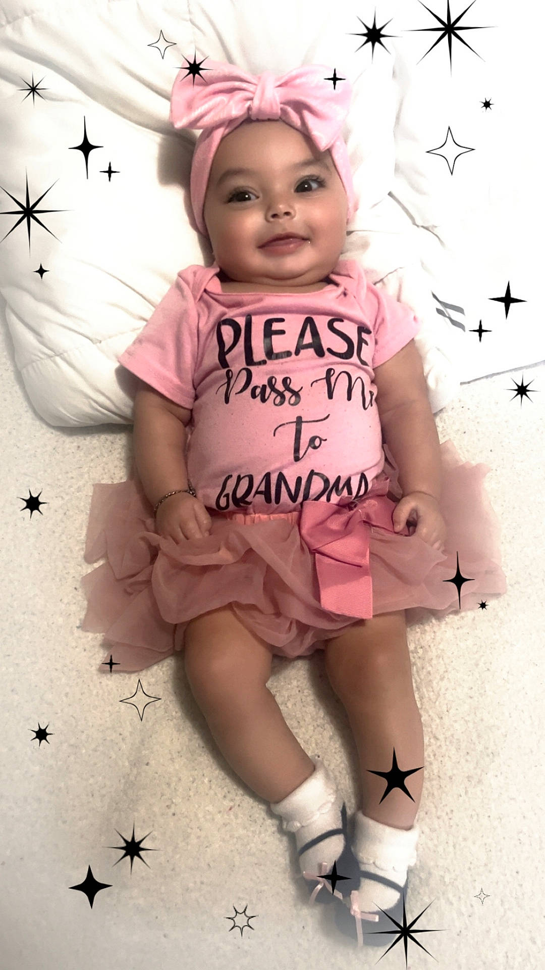 Kehlani is registered to the contest to win money with this photo: baby, bed, blanket, bow, carpet, child, dress, grandma, headband, indoor, infant, lying_down, onesie, pink, portrait, smiling, sparkles, stars, text, tutu