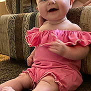 Eiley joined the competition — help win amazing prizes! baby, infant, smiling, pink_clothing, sitting, carpet, couch, indoor, child, cute, happy, person, young_child, furniture, hand, portrait, ruffles, skin, legs, expression