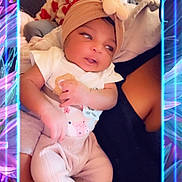 Keeara is registered to the contest to win money with this photo: baby, infant, headband, clothing, person, holding, arms, indoor, portrait, cute, neon_frame, colorful, floral_background, cozy, pink, purple, smiling, closeup, child, soft