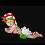 baby, infant, smiling, hat, knitted, red, white, green, bow, leg_warmers, diaper_cover, frilly, cute, lying_down, portrait, blue_eyes, holiday, festive, black_background, child