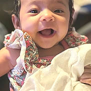Brynn joined the competition — help win amazing prizes! baby, child, smiling, happy, face, blanket, clothing, floral_pattern, dress, soft, cute, portrait, indoors, infant, young_child, ruffle, skin, hand, person, bright