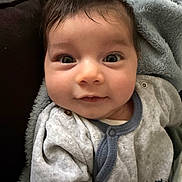 Sina participe au concours pour gagner de l'argent avec cette photo : baby, blanket, child, closeup, clothing, cozy, cute, expression, eyes, face, hair, indoors, infant, onesie, person, portrait, skin, smile, soft, young