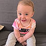 Emilia a rejoint le concours — aidez-le/la à gagner de superbes lots ! baby, blue_eyes, child, clothing, couch, cute, face, feet, hair, hands, happy, indoor, infant, nike, pants, person, shirt, sitting, smiling, texture