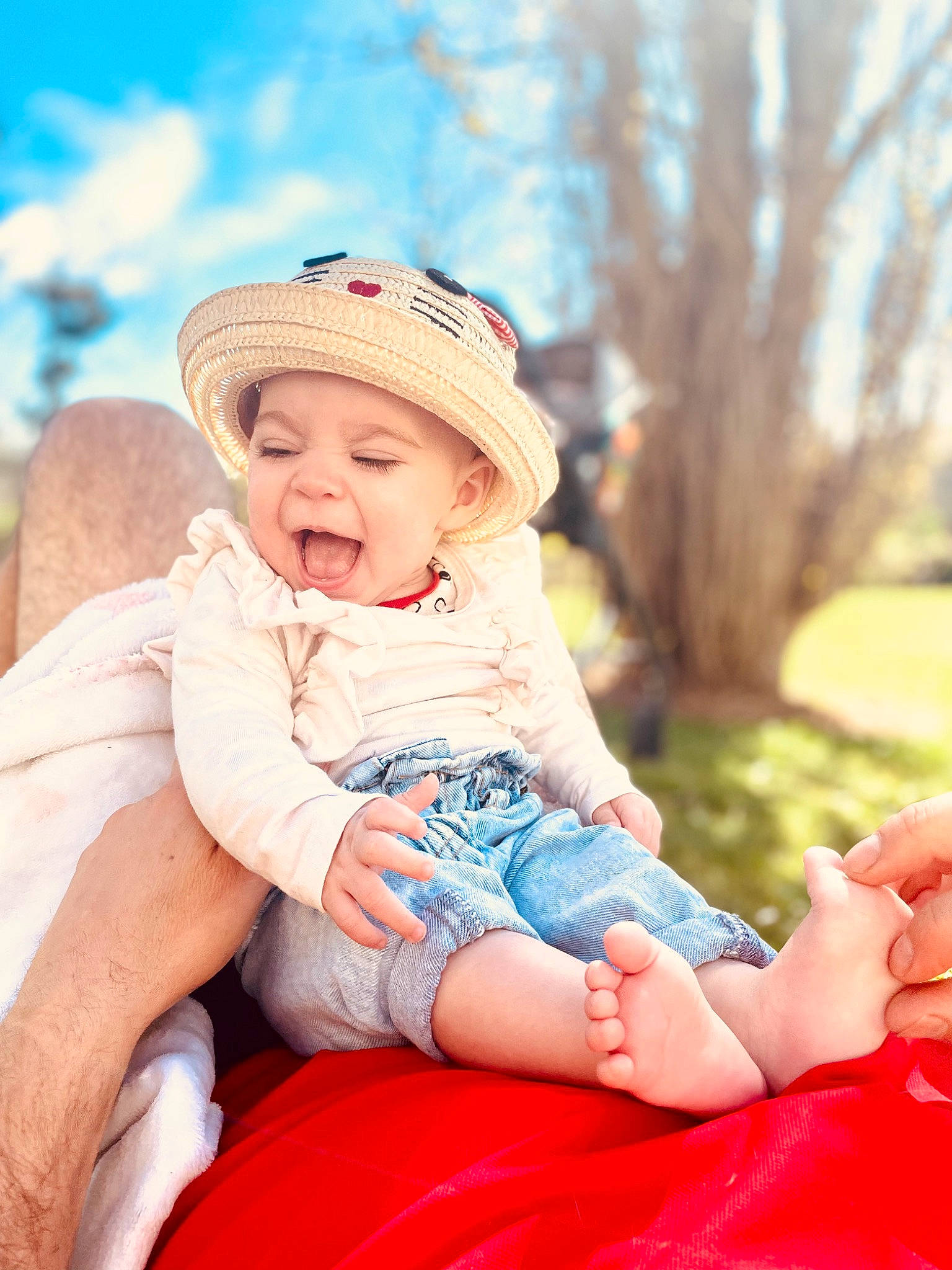 Léna a rejoint le concours — aidez-le/la à gagner de superbes lots ! baby, baby_toddler_clothing, cap, child, electric_blue, flash_photography, fun, grass, happy, hat, headwear, human_leg, leisure, people_in_nature, person, pink, sitting, skin, sky, sun_hat