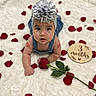 Camila is registered to the contest to win money with this photo: baby, infant, child, portrait, lying_down, wide_eyed, flower_headband, denim_overalls, white_blanket, rose_petals, red_rose, wooden_sign, milestone_photo, three_months, indoor, studio_photography, fluffy_texture, floral_theme, centered_composition, face