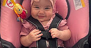 Camila joined the competition — help win amazing prizes! baby, infant, child, smiling, portrait, stroller, pink, bow, headband, harness, seatbelt, toy, plush_toy, colorful, sitting, outdoor, happy, face, socks, closeup