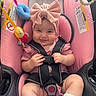 baby, infant, child, smiling, portrait, stroller, pink, bow, headband, harness, seatbelt, toy, plush_toy, colorful, sitting, outdoor, happy, face, socks, closeup