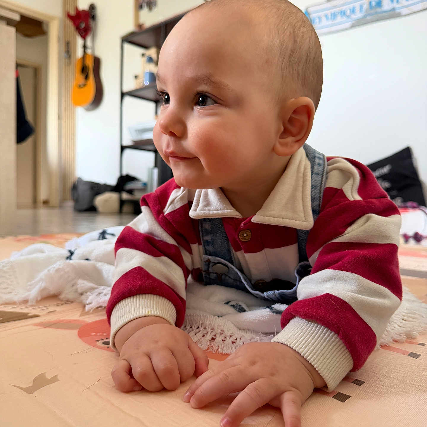 Soren participe au concours pour gagner de l'argent avec cette photo : baby, candid, casual, child, curious, face, floor, guitar, hands, home, indoor, infant, overalls, person, play_mat, portrait, shelf, soft_lighting, striped_clothing, toddler