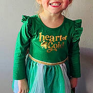 Ophelia joined the competition — help win amazing prizes! child, girl, smiling, green_dress, bow, boots, standing, chair, happy, portrait, indoor, long_sleeves, tulle_skirt, gold_text, light_hair, casual, cute, fashion, wall, floor