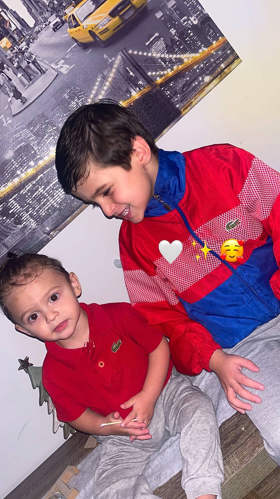 Milano participe au concours pour gagner de l'argent avec cette photo : boy, candid, child, cityscape_poster, emoji_stickers, gray_sweatpants, happy_expression, indoor, lacoste_logo, portrait, red_jacket, red_polo, short_hair, siblings, sitting, smiling, toddler, wall_art, wooden_floor, yellow_taxi