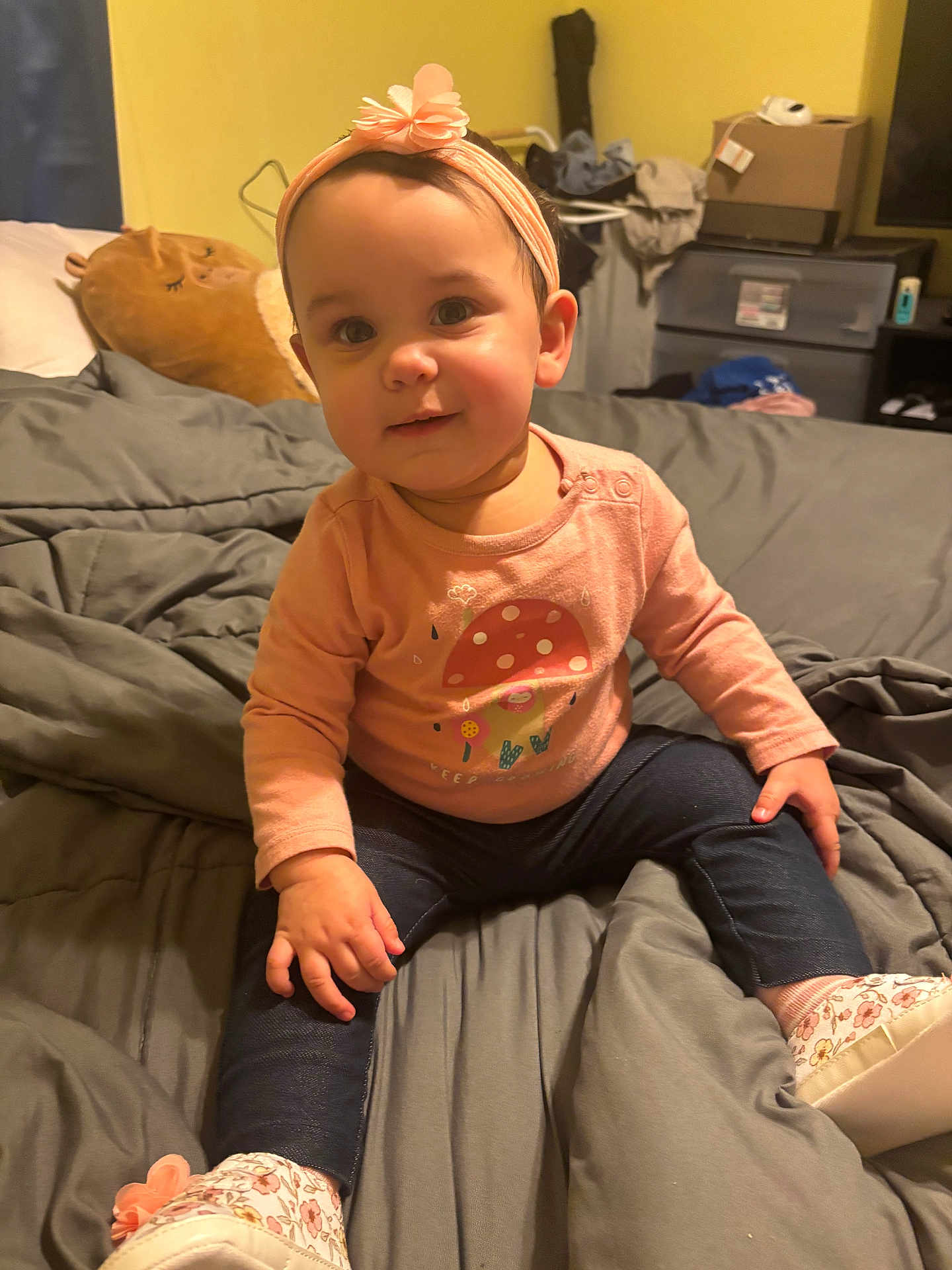 Jaelynn joined the competition — help win amazing prizes! baby, child, girl, headband, flower, pink_clothing, mushroom_design, sitting, bed, blanket, pillow, indoor, cozy, smile, cute, footwear, denim_leggings, room, soft_lighting, portrait