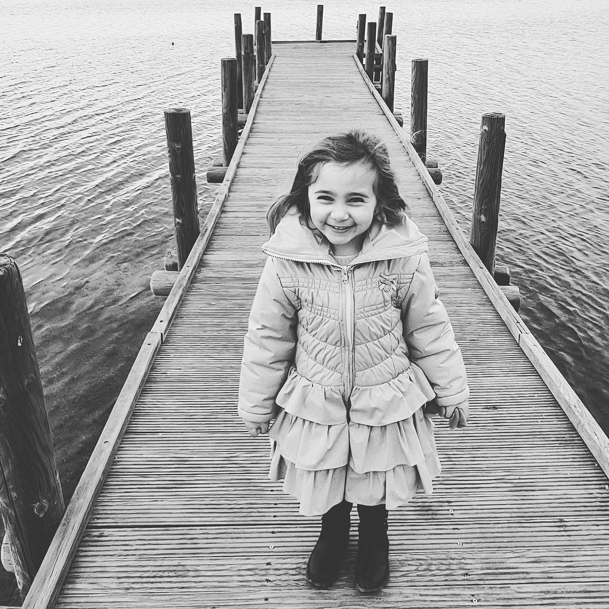 Emma participe au concours pour gagner de l'argent avec cette photo : black_and_white, boardwalk, boot, deck, dock, happy, human_body, jacket, joy, monochrome, monochrome_photography, nonbuilding_structure, people_in_nature, person, photography, pier, portrait_photography, sleeve, standing, walkway