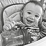 baby, high_chair, sippy_cup, smile, child, indoor, happy, face, clothing, person, table, feeding, young_child, cute, infant, expression, holding, seat, joyful, portrait