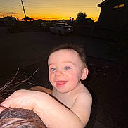 Khost is registered to the contest to win money with this photo: baby, child, smiling, face, blue_eyes, hair, hand, skin, outdoor, sunset, silhouette, car, house, person, night, flash, holding, happy, portrait, head