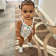 Daleyza joined the competition — help win amazing prizes! toddler, child, indoor, carpet, patterned_rug, standing, looking_at_camera, hair_tied, pigtails, onesie, footwear, flooring, home_interior, expression, cute, young_child, small_person, earrings, skin, person