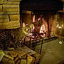 cat, tabby, fireplace, firewood, fire, stone_wall, indoor, cozy, warm, animal, pet, curious, wood, hearth, glow, metal_frame, mesh_screen, floor, home, relaxation