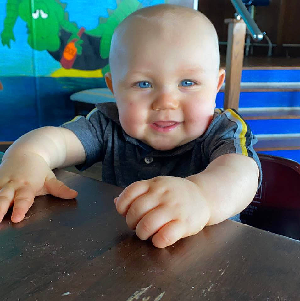 Kylan joined the competition — help win amazing prizes! baby, baby_toddler_clothing, blue, cheek, child, facial_expression, finger, floor, flooring, fun, happy, hardwood, joy, person, sitting, smile, standing, table, thumb, toddler