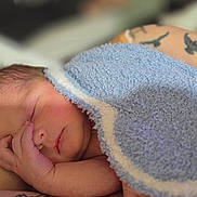 Noah joined the competition — help win amazing prizes! newborn, baby, sleeping, infant, blanket, blue_blanket, adult, hand, tattoo, arm, portrait, close_up, indoors, resting, peaceful, cozy, soft_lighting, family, parenting, nap