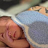 newborn, baby, sleeping, infant, blanket, blue_blanket, adult, hand, tattoo, arm, portrait, close_up, indoors, resting, peaceful, cozy, soft_lighting, family, parenting, nap