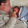 Noah is registered to the contest to win money with this photo: baby, newborn, adult, bottle_feeding, bed, pillow, blanket, indoor, bedroom, parent, family, sleeping, feeding, portrait, closeup, reclining, soft_lighting, cozy, clothing, home