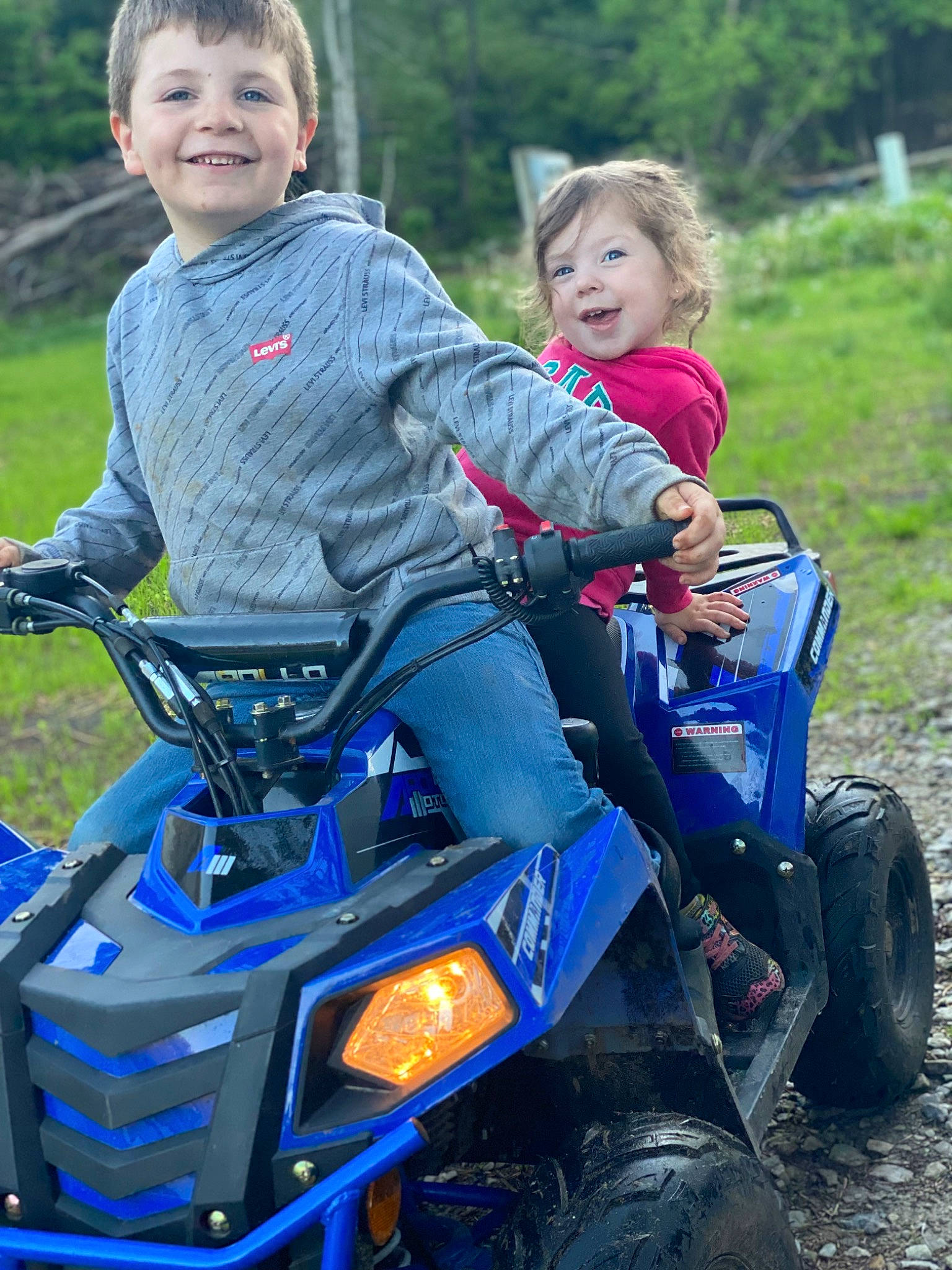 Addilyn is registered to the contest to win money with this photo: automotive_design, automotive_exterior, automotive_tire, blue, electric_blue, fender, fun, grass, head, joy, leisure, motor_vehicle, motorsport, outdoor_recreation, person, recreation, t_shirt, tire, toddler, tree