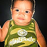 toddler, child, portrait, green_tank_top, camouflage, backlit, glow, serious_expression, baby, isolated, dark_background, short_hair, face, skin, young, indoors, person, front_view, cute, casual_clothing