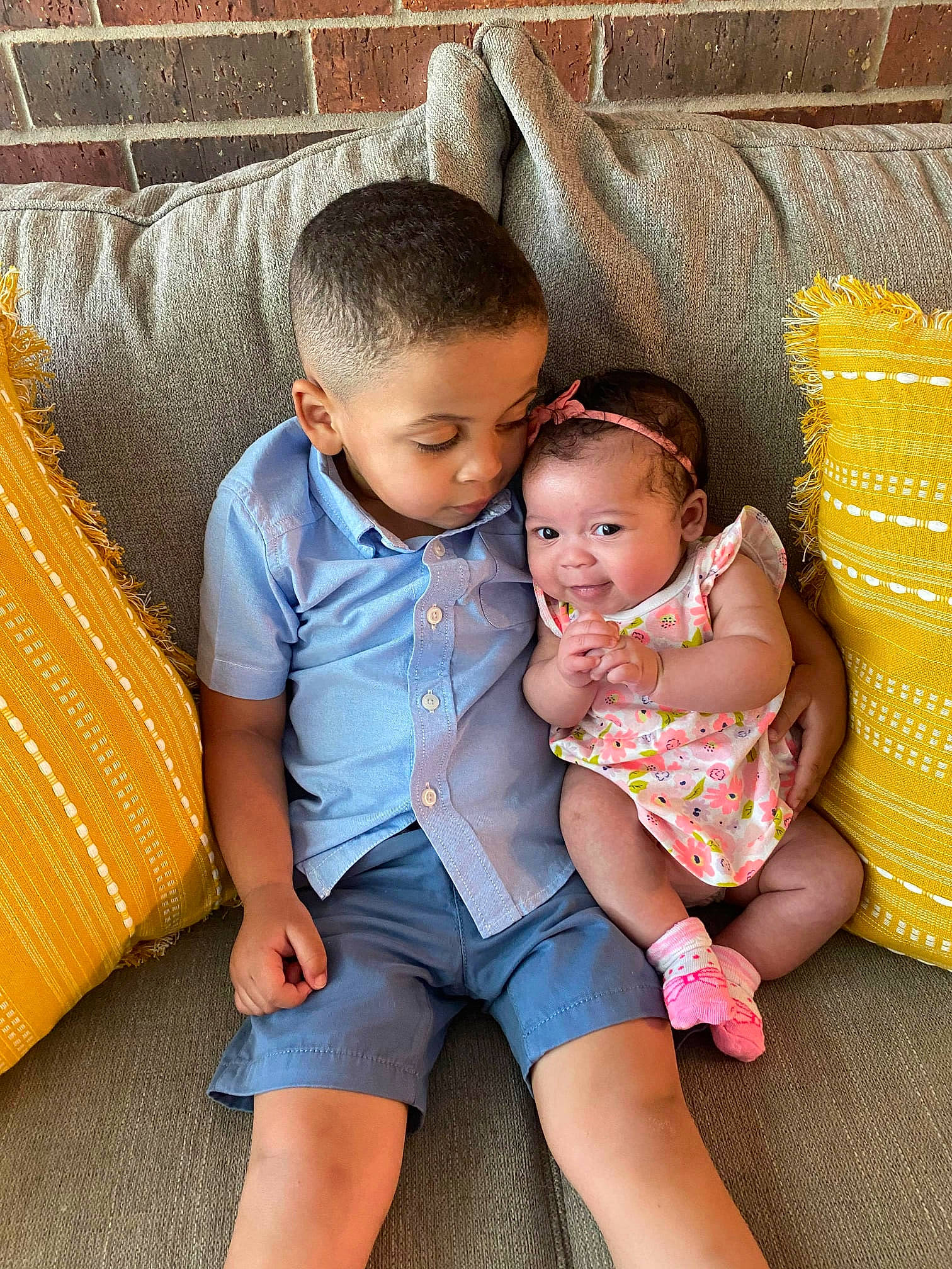 Braiden joined the competition — help win amazing prizes! baby, baby_toddler_clothing, comfort, couch, dress, eye, face, facial_expression, hairstyle, happy, head, human_body, interaction, iris, lap, leg, person, product, skin, thigh