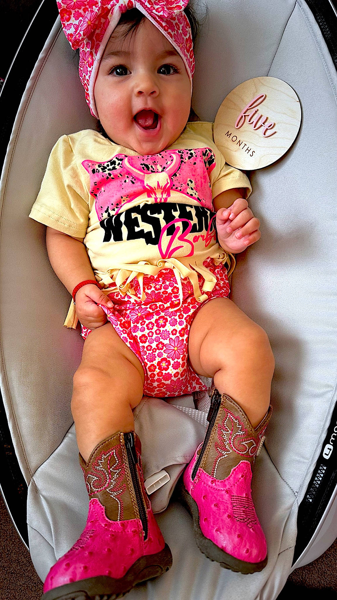 Maddison is registered to the contest to win money with this photo: baby, baby_toddler_clothing, cheek, child, fashion_accessory, fun, happy, headwear, human_leg, knee, leg, magenta, pattern, person, pink, sitting, sleeve, smile, surprise, t_shirt