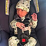 baby, infant, car_seat, child, pajamas, hat, animal_print, straps, safety_harness, cute, newborn, clothing, seat, child_safety, face, person, small_hand, looking_away, indoors, soft_fabric