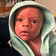 Elijah is registered to the contest to win money with this photo: baby, child, closeup, cute, expression, face, hand, hooded_towel, human, indoor, infant, newborn, person, portrait, skin, soft_texture, surprised, towel, wide_eyes, wrapped